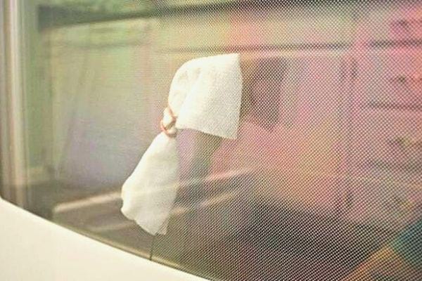 Un mouchoir accroché à un cintre inséré dans l'espace de la vitre du four 