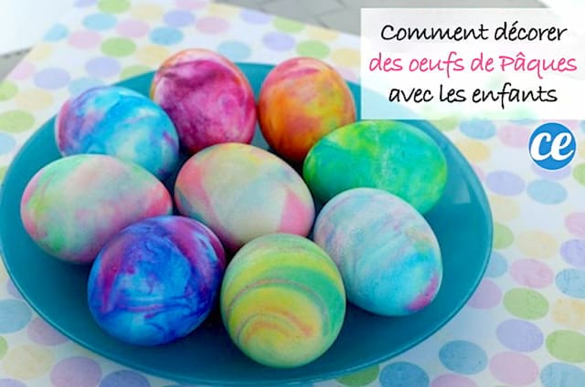 Plusieurs oeufs de pâques colorés dans une assiette bleue 
