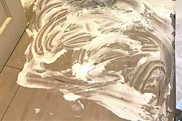 De la mousse à raser étalée sur le sol en carrelage 