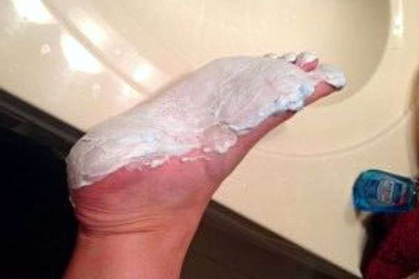 De la mousse à raser sur le pied d'une personne 