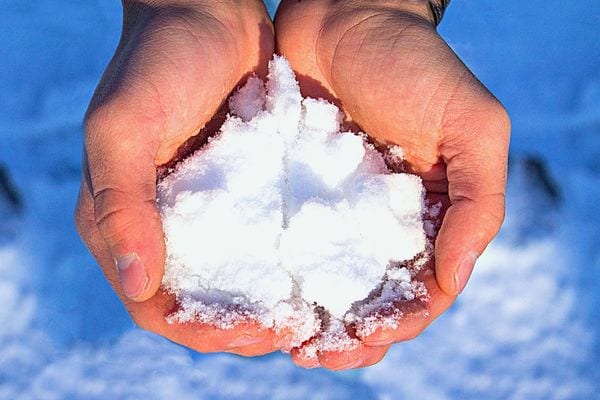 Une personne tenant de la neige dans ses mains