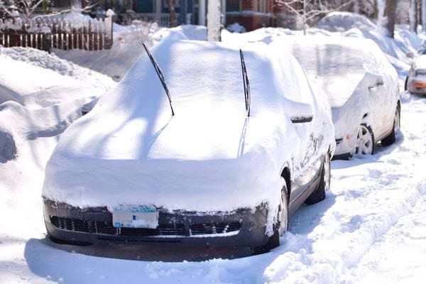 Two cars that are covered in snow 