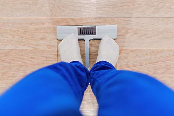 Une personne avec un pantalon bleu sur un pèse personne 