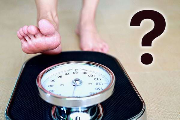 Une personne pieds nus s'apprêtant à monter sur un pèse personne 