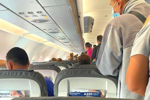 Des personnes debout et assises à l'intérieur d'un avion