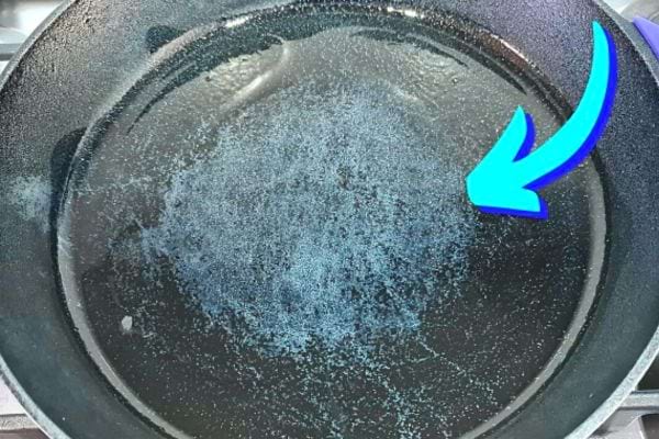 Une poêle noir avec des signes d'usures dessus