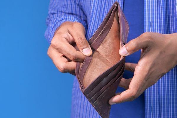 Une personne tenant son porte-monnaie marron vide 