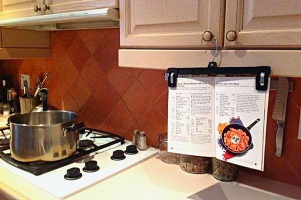 Une recette de cuisine suspendue à un cintre qui est accroché à un placard de cuisine 