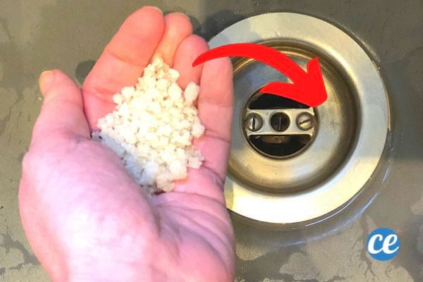 Grobes Salz in der Hand einer Person über einem Waschbecken