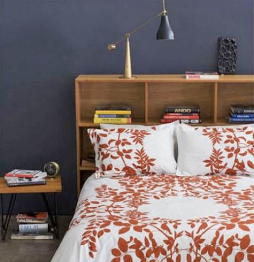 Une tête de lit avec plusieurs petites étagères et une lit fleurale
