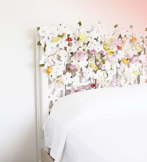 Un lit blanc avec une tête de lit faites avec des fleurs