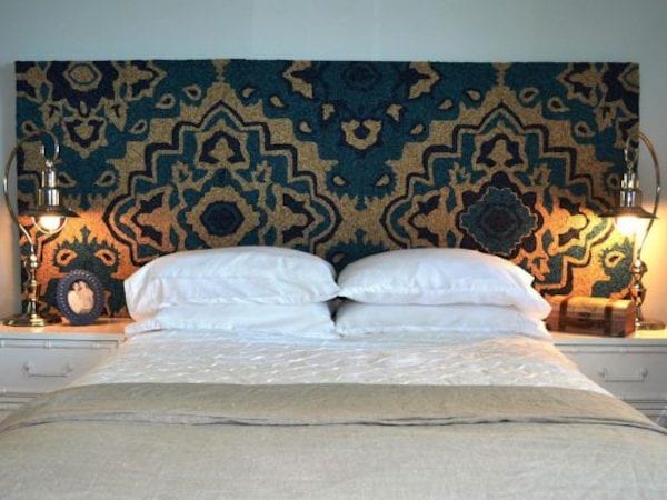 Un lit avec une tête de lit avec un style orientale avec des couleurs sombres