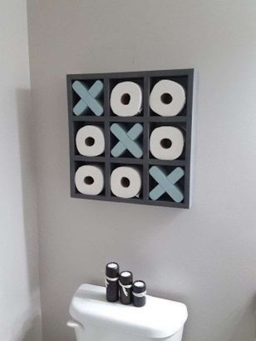 Toilets with small shelves for toilet paper that look like a noughts and crosses 