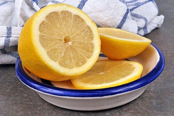 Une petite assiette avec du citron jaune découpé 