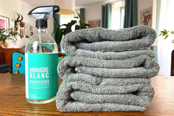 serviettes de toilette grise et spray de vinaigre blanc