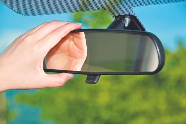 main sur un rétroviseur intérieur de voiture