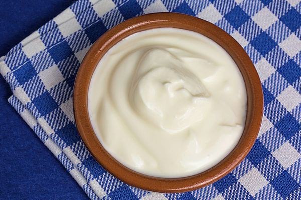 Du yaourt à la grecque sur un torchon à carreaux bleu et blanc 