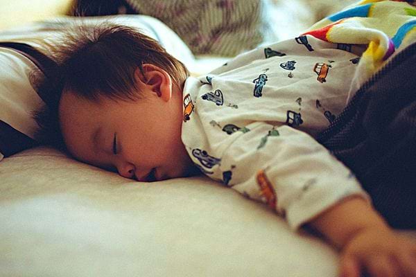 Un bébé qui dort sur son lit 