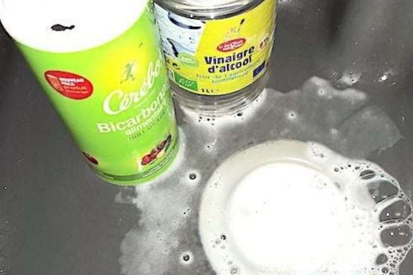 Du bicarbonate et du vinaigre d'alcool dans un évier avec de la mousse