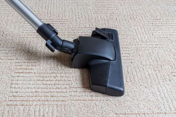 La brosse noire d'un aspirateur sur de la moquette