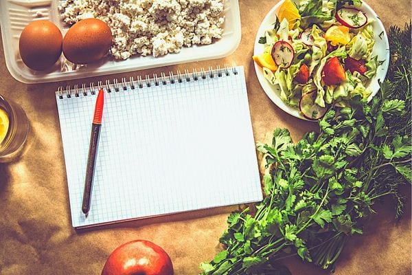 Un cahier de note au milieu de plusieurs aliments 