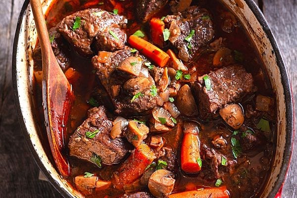 Une cocotte remplie de bouyon de viande avec des carottes 