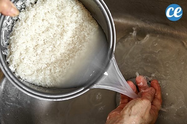 Une personne nettoyant du riz avec de l'eau dans une casserole