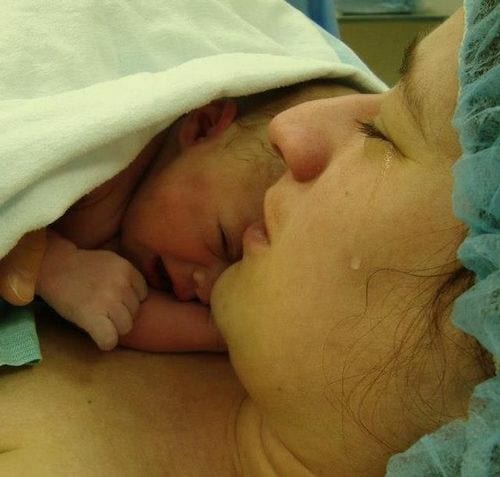 Une femme avec une larme qui vient de donner naissance 