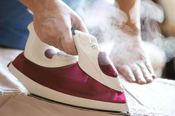 Une personne qui passe le fer à repasser 