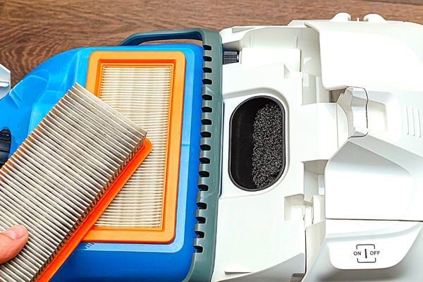 Une personne tenant le filtre d'un aspirateur 