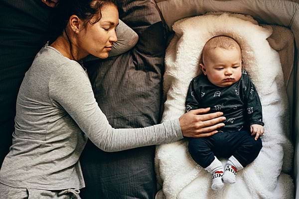 Une mère qui a la main gauche posée sur le ventre de son bébé