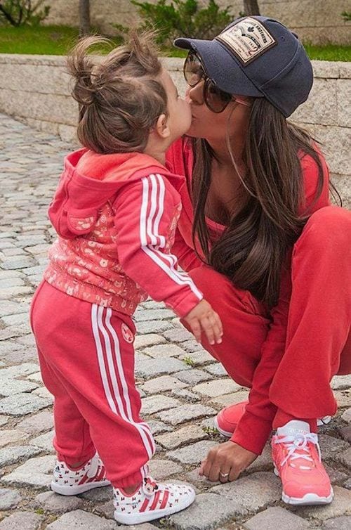 Une mère avec sa fille qui sont vêtues d'un survêtement rose Adidas
