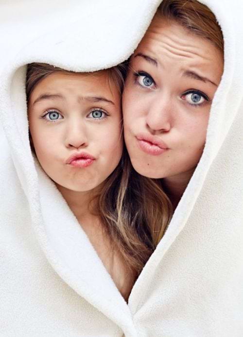 Une mère avec sa fille qui ont les yeux bleus entouré d'une serviette