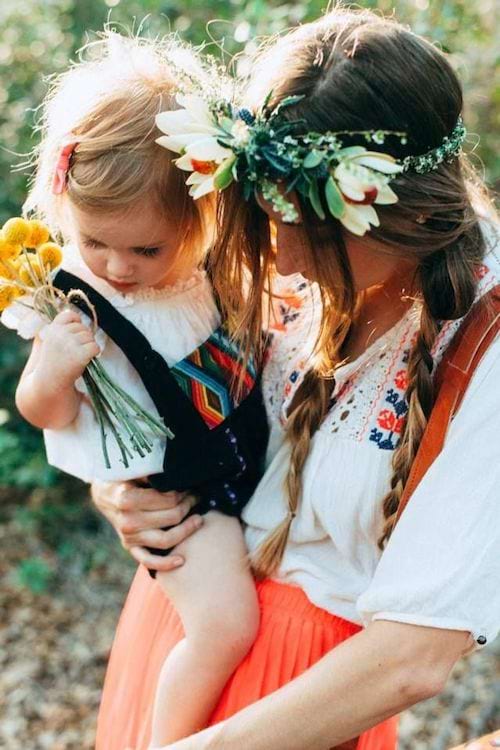 Une mère qui porte sa fille avec des fleurs