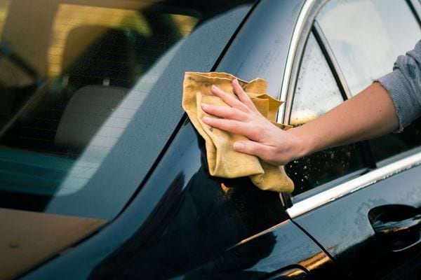 Une personne qui nettoie sa voiture noir 