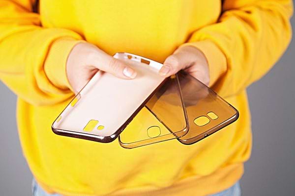 Une personne avec un pull jaune qui tient trois coques 