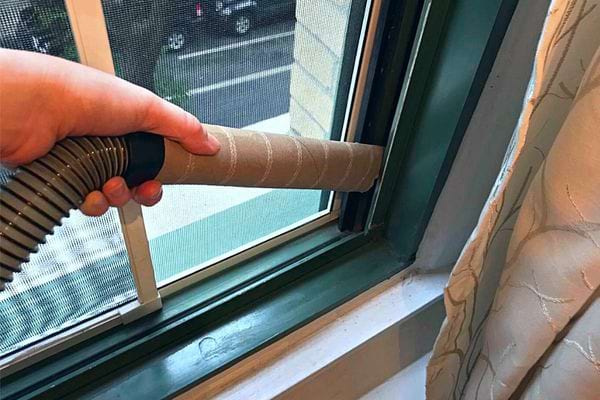 Eine Rolle Papierhandtuch, die auf die Düse eines Staubsaugers gelegt wird
