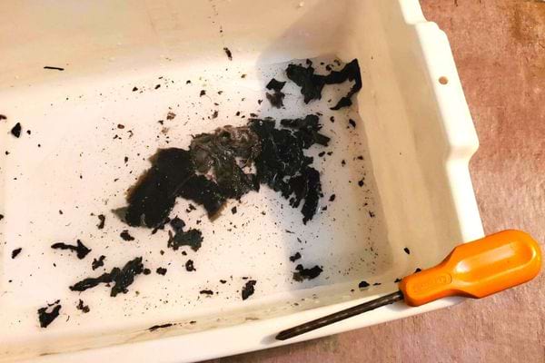 La saleté d'un siphon avec un tournevis orange