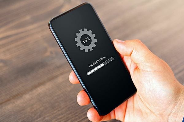 Une personne tenant un téléphone noir qui fait une mise à jour 