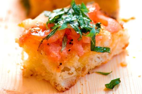 Un petit toast façon bruschetta avec du saumon par dessus et des fines herbes