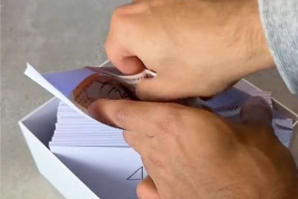 Une personne mettant un billet d'argent dans une enveloppe