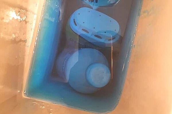 Une bouteille en plastique dans un réservoir de toilette 