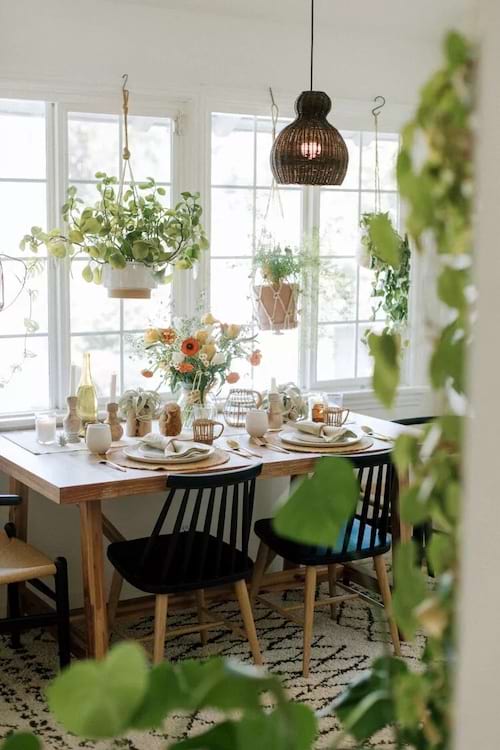 Uma sala de jantar com plantas penduradas ao redor