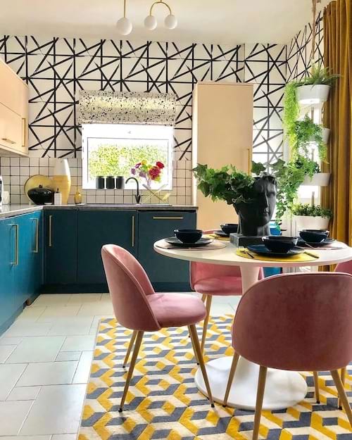 Une cuisine avec une table ronde et plusieurs plantes dans des pots blancs superposées 