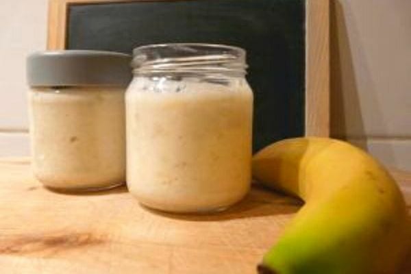 Zwei kleine Gläser gefüllt mit zerdrückten Bananen mit Zucker