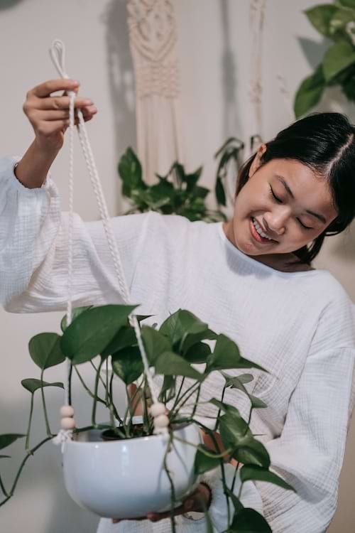 Une femme asiatique qui tient une plante avec une corde blanche 