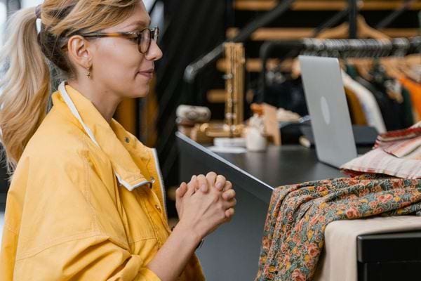 Une femme avec une veste jaune devant une caisse 