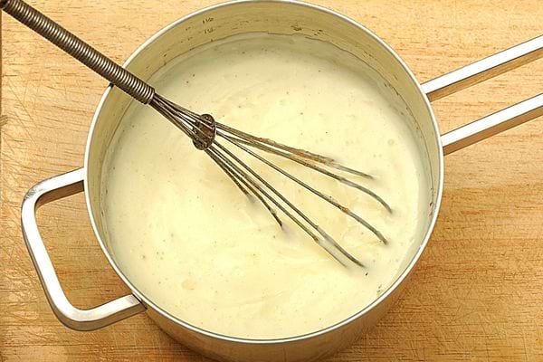 Une grosse casserole de sauce avec une spatule