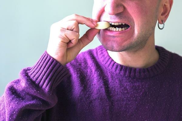 Un homme qui mange de l'ail pour se débarrasser des vers intestinaux