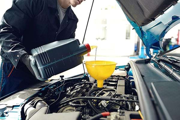 Une mécanicien qui change l'huile d'une voiture 